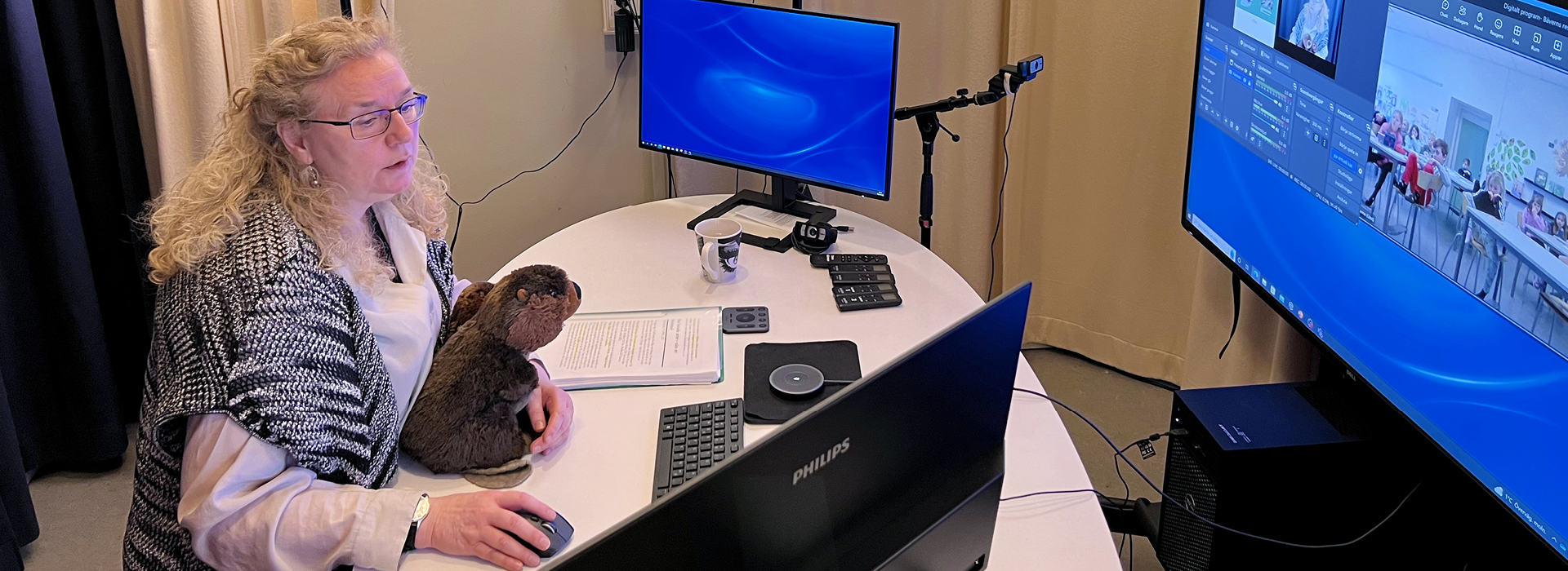 En pedagog sitter framför datorskärmar